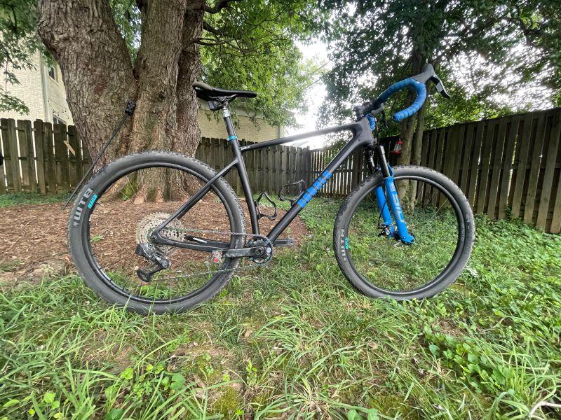 Titanium Cobalt gravel build with blue fork in a garden